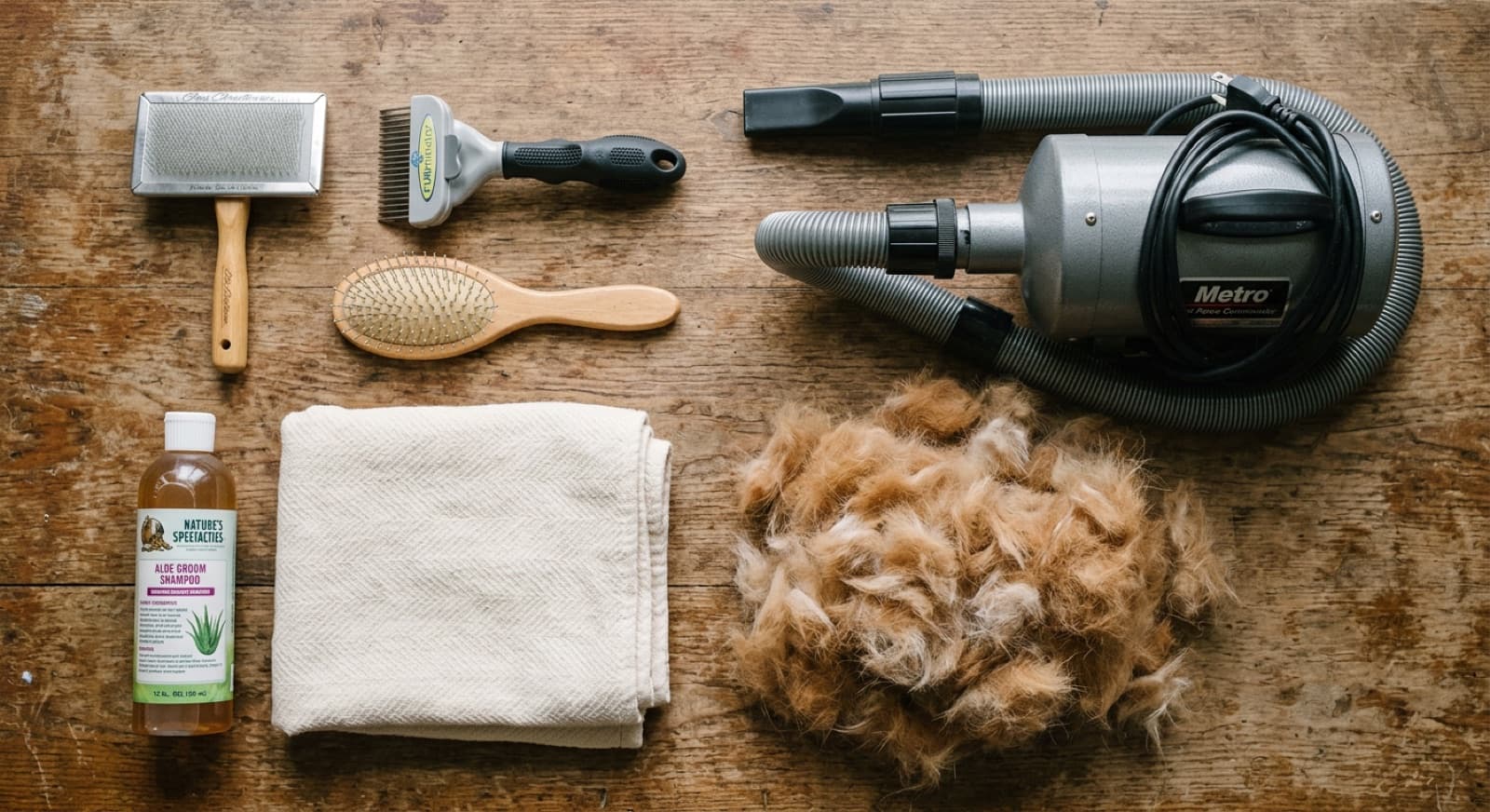 A Shiba Inu grooming tool kit laid out on a Calgary kitchen counter: slicker brush, undercoat rake, pin brush, mat splitter, nail grinder, and ear cleaner